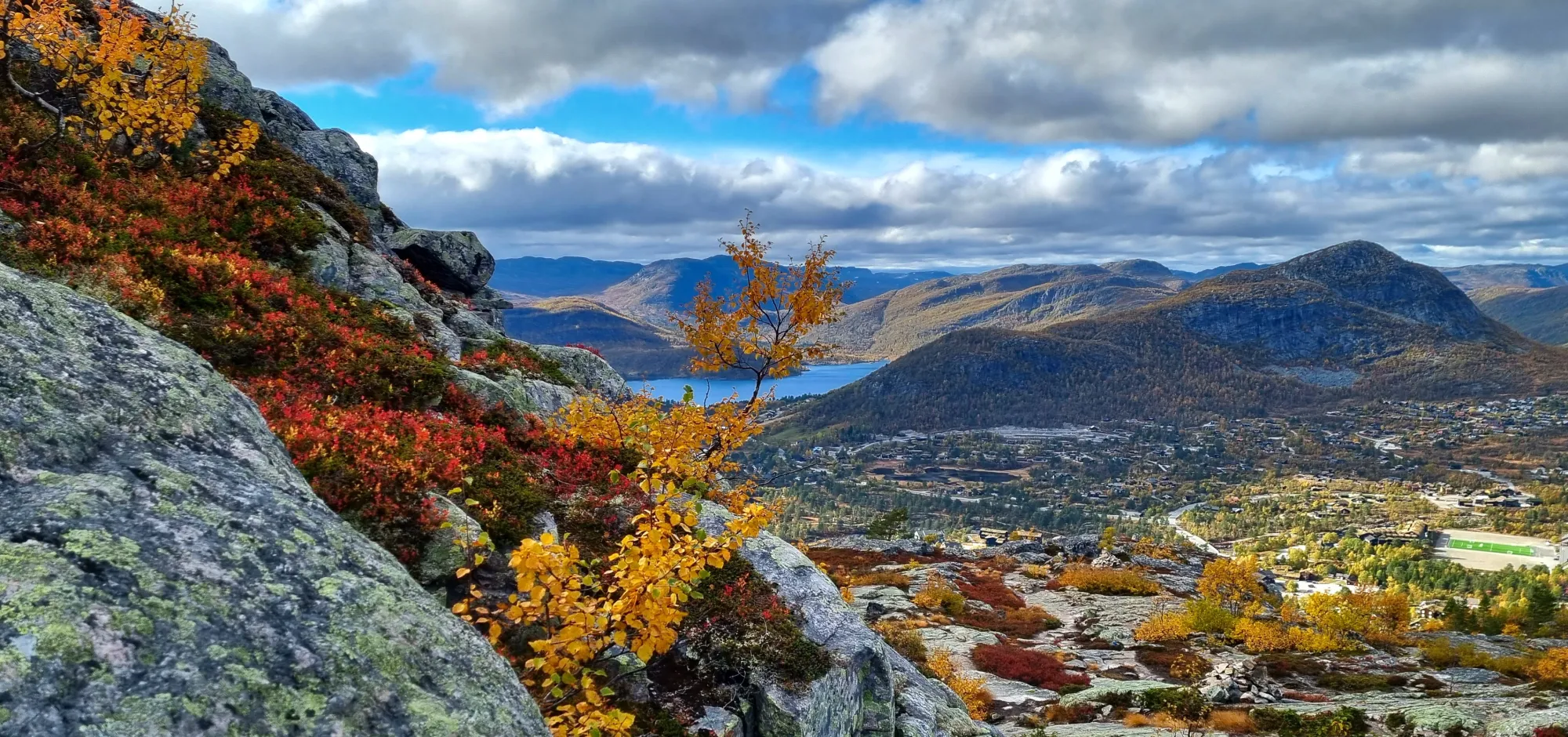 Utsikt over Hovden og fjellene fra Hartevassnuten. Høstfarger på busker og trær.
