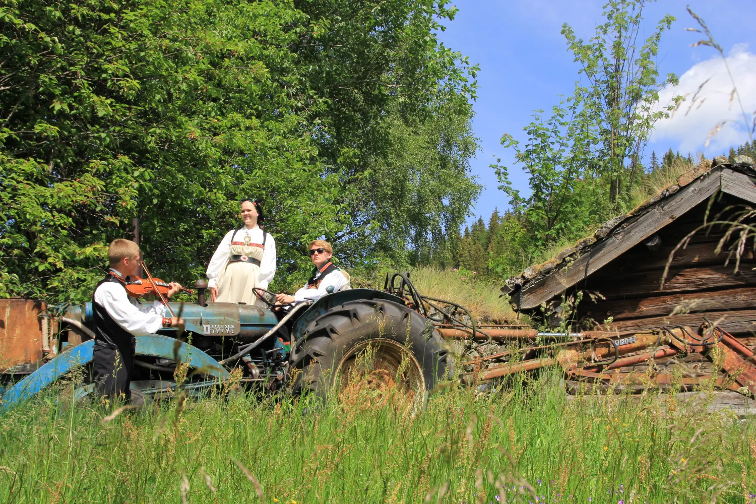 Kulturpatrujla underholder på /ved en gammel traktor i gårdsmiljø