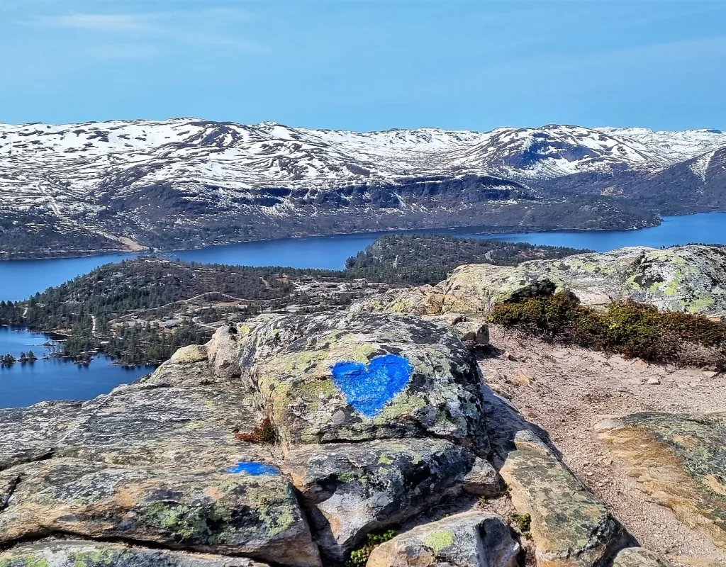 Utsikt over Hovden og fjellene fra Hartevassnuten. Litt snø på toppene, isfritt vann